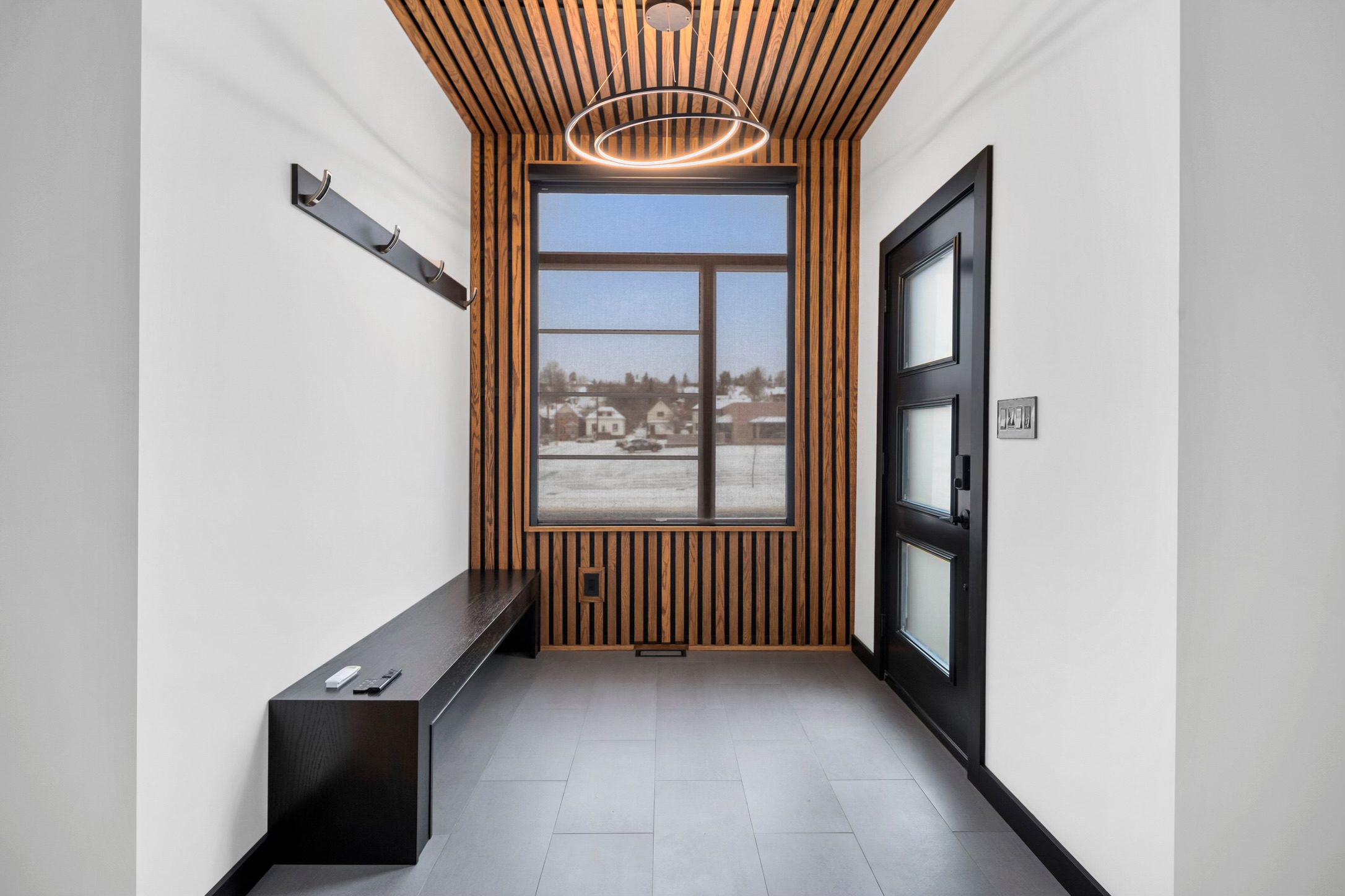 Entryway with wood slat wall and ceiling